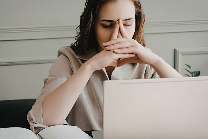 Nachdenkliche Frau vor dem Laptop